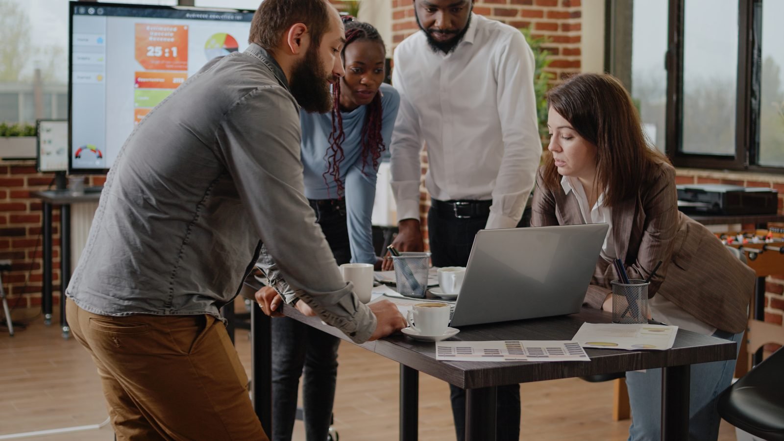 A marketing team reviewing an email campaign together on a laptop
